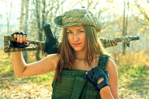 Wojskowa dziewczyna z kopią karabinu szturmowego Kałasznikowa w kamizelkę kuloodporną i kapelusz. — Zdjęcie stockowe