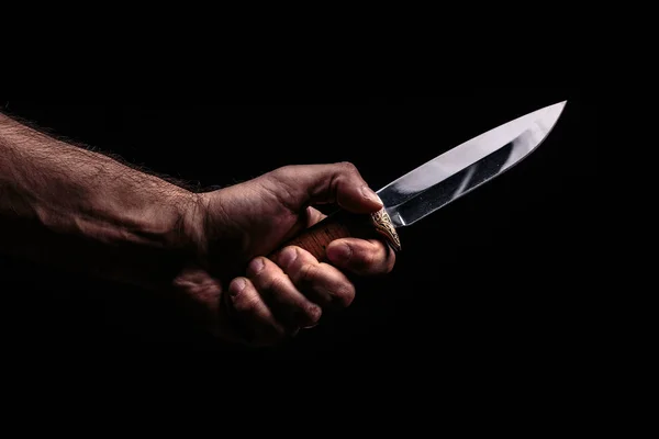 Nóż myśliwski w ręku na ciemnym tle — Zdjęcie stockowe