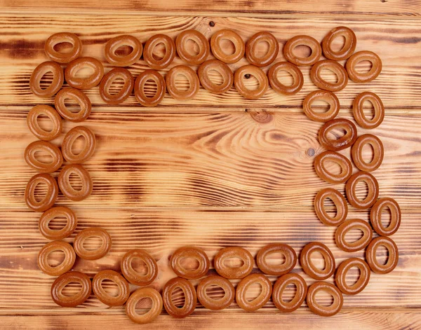 Heap of bagels scattered on the wooden table with copy space — Stock Photo, Image