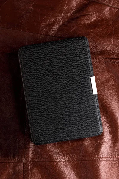 Electronic book in the case on leather background