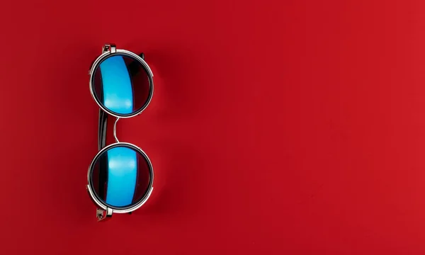 Sonnenbrille auf rotem Hintergrund mit Kopierraum. Der Sommer kommt. — Stockfoto