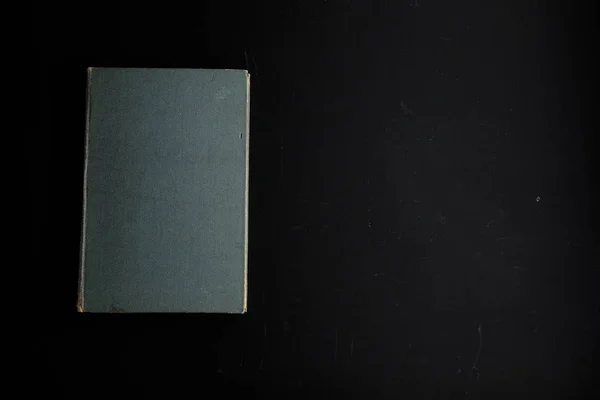 Bardzo stara książka z postrzępione okładka na brudnym ciemnym tle. — Zdjęcie stockowe