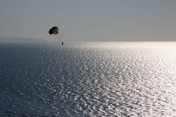 Silhouette of skydiver flying to sky on sunset — Stock Photo, Image