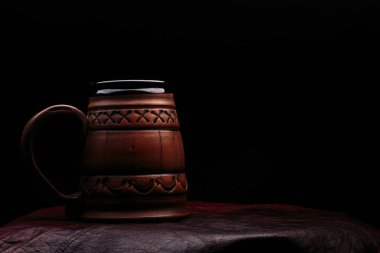 Koyu renkli bir arka planda kil bira bardağı. Kopyalama alanı ile.