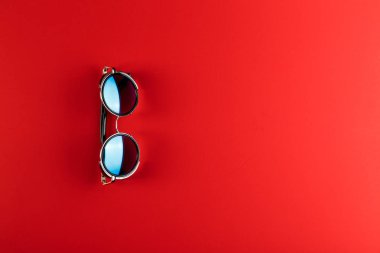 Kopya alanı ile kırmızı arka plan üzerinde güneş gözlüğü. Yaz konsepti geliyor.