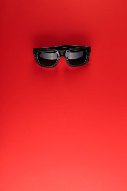 Kopya alanı ile kırmızı arka plan üzerinde güneş gözlüğü. Yaz konsepti geliyor.