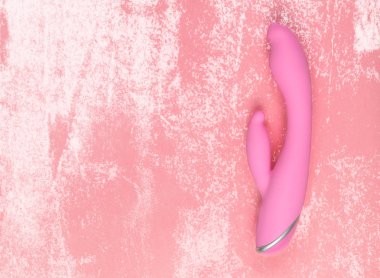 Kopya alanı ile kirli bir arka planda büyüleyici bir eşit aydınlatılmış Pembe Dildo.