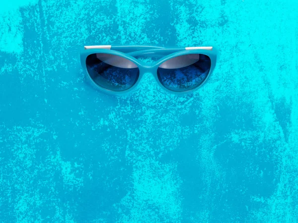 汚れた青い背景にスタイリッシュな青いサングラス。夏が近づいているコンセプト. — ストック写真