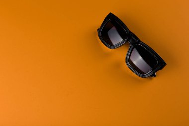 Kopya alanı ile sarı arka plan üzerinde güneş gözlüğü. Yaz konsepti geliyor.