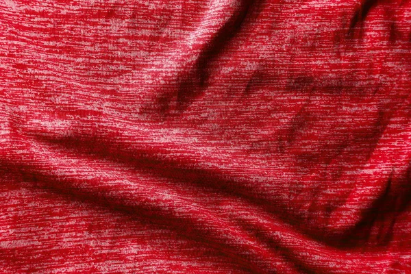Uma textura de tecido vermelho uniformemente iluminado com sombras suaves . — Fotografia de Stock