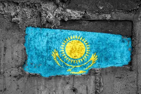 The flag of Kazakhstan on a dirty wooden surface, built into a concrete base, with scuffs and scratches. Loss or destruction conception.