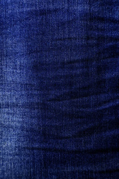 Kontrasterande blå denim textur med veck på vissa ställen. — Stockfoto