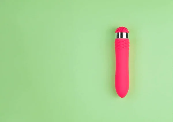 Belo vibrador rosa uniformemente iluminado em um fundo verde simples com espaço de cópia . — Fotografia de Stock