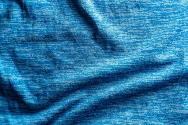 Yumuşak gölgelerle tek renkli aydınlatılmış mavi kumaş dokusu.