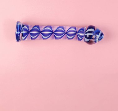 Kopya alanı ile düz pembe arka planda güzel eşit aydınlatmalı cam dildo.
