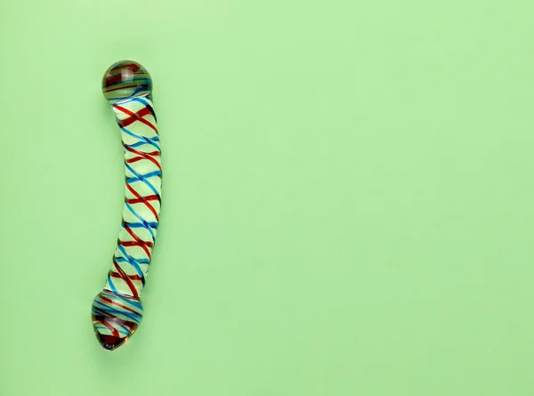 Kopya alanı ile düz yeşil arka planda güzel eşit aydınlatmalı cam dildo.