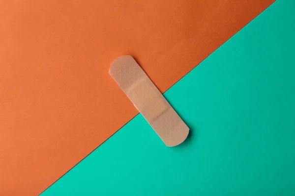 Venda adhesiva o yeso adhesivo sobre un fondo de papel de dos colores . —  Fotos de Stock