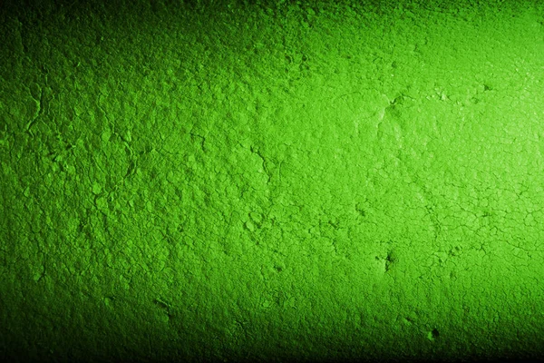 Color green background of dirty porous material. Illuminated by a narrow strip of light, with shadows on the edges of the image.