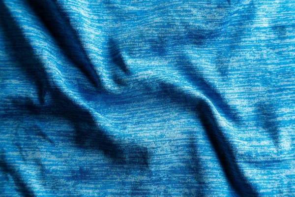 Une texture de tissu bleu uniformément éclairé avec des ombres douces . — Photo