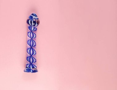 Kopya alanı ile düz pembe arka planda güzel eşit aydınlatmalı cam dildo.