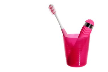 Yalnız kız seti. Kopya alanı ile beyaz arka plan üzerinde izole plastik bir fincan pembe vibratör ve diş fırçası.