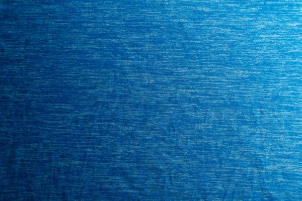 Une texture de tissu bleu uniformément éclairé avec des ombres douces . — Photo