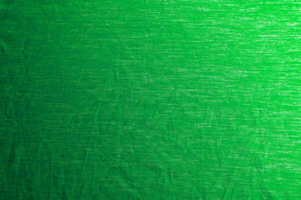 Uma textura de tecido verde uniformemente iluminada com sombras suaves . — Fotografia de Stock