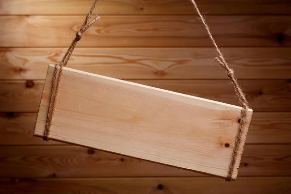 Letrero de madera sobre una cuerda áspera sobre un hermoso fondo de madera —  Fotos de Stock
