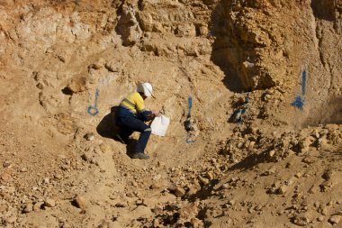 Mine Geologist Sampling Rocks in Open Pit clipart