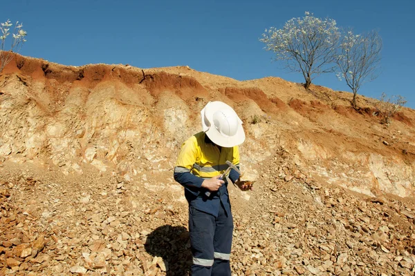 Mine Geologist Sampling Rocks in Open Pit