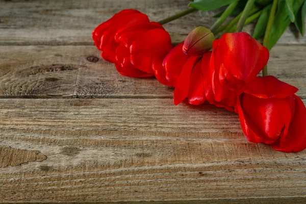 Bouquet of red tulips on a wooden background