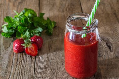 Smoothies çilek-nane ahşap arka plan üzerinde bir kavanoz içinde