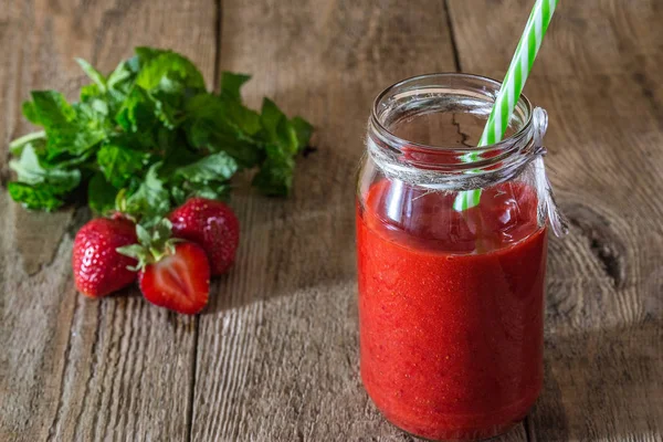 Smoothies çilek-nane ahşap arka plan üzerinde bir kavanoz içinde