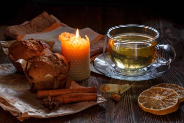 Bardak ıhlamur çayı ve cupcakes kahverengi ahşap arka plan üzerinde.