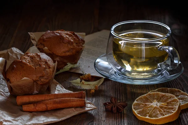 Bardak ıhlamur çayı ve cupcakes kahverengi ahşap arka plan üzerinde.
