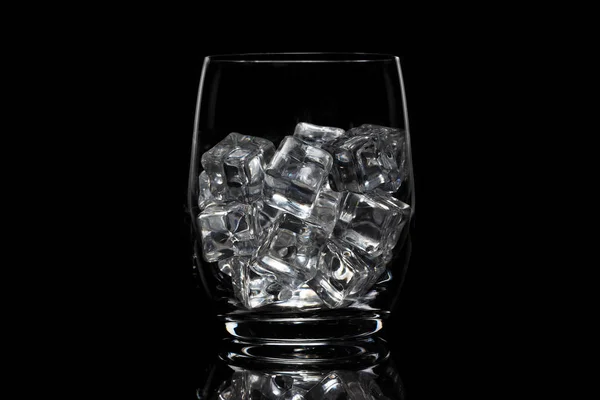 Glass cup with ice on a black background