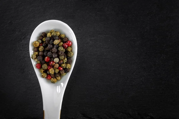 Especias de granos de pimienta en una cuchara — Foto de Stock