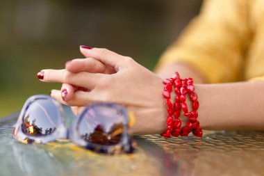 Women's hands on the table in the summer cafe