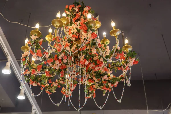 Chandelier decorated with artificial flowers and beads — Stock Photo, Image