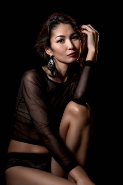 Siyah iç çamaşırlarıyla poz veren Asyalı bir kız.