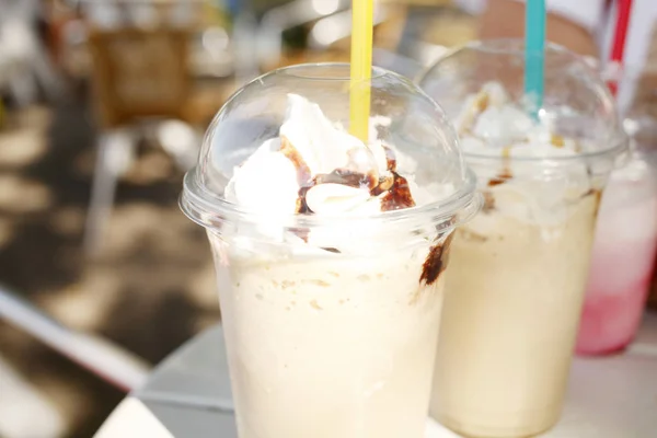 昼間の公園でテーブルの上のチョコレートとクリーム コーヒー カフェラテの大きな部分のクローズ アップ — ストック写真