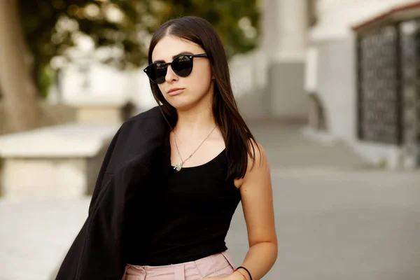 黒のジャケットとサングラスを身に着けている健康なストレートヘアと美しい若い学生の内気な少女 ストリート スタイル — ストック写真