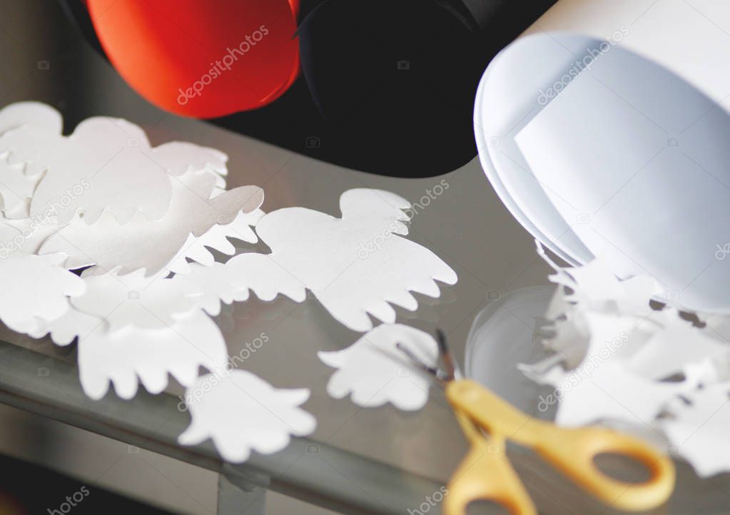 Closeup view of Halloween paper decorations on table with scissors and pieces of colored paper  