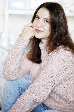 Güzellik esmer kadın giyiyor mavi kot pantolon ve kış kazak, arka plan bulanık closeup portresi