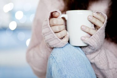 Mavi jeans ve kış kazak holding fincan çay, arka plan bulanık giyen güzellik esmer kadın portresi portre