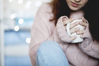 Mavi jeans ve kış kazak holding fincan çay, arka plan bulanık giyen güzellik esmer kadın portresi portre