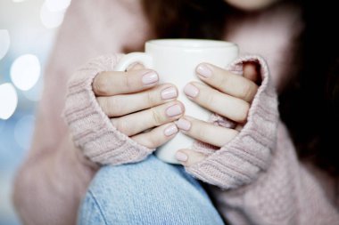 Mavi jeans ve kış kazak holding fincan çay, arka plan bulanık giyen güzellik esmer kadın portresi portre