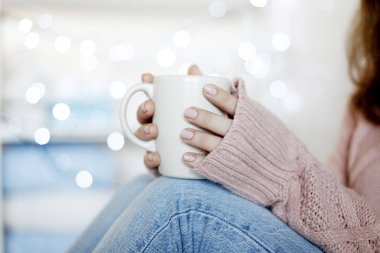 Mavi jeans ve kış kazak holding fincan çay, arka plan bulanık giyen güzellik esmer kadın portresi portre