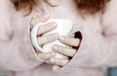 Mavi jeans ve kış kazak holding fincan çay, arka plan bulanık giyen güzellik esmer kadın portresi portre