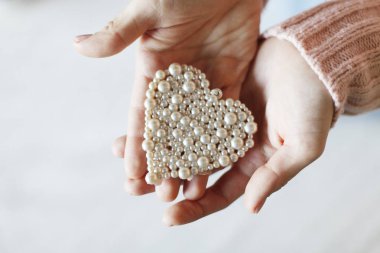 Erkek küçük inci kalp tutan eller